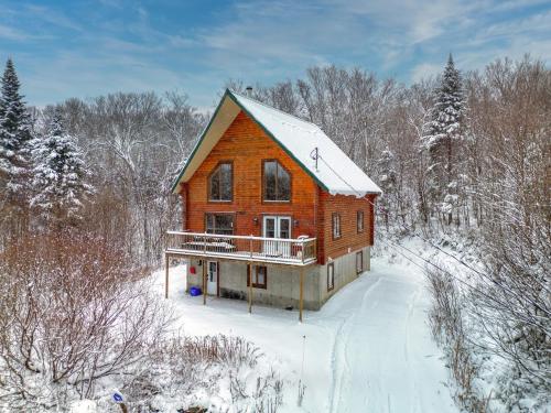 a large wooden house in the snow in the woods at Chalet Cerf for 16 Guests, 7 min to SPA, Skiing in Saint-Paul-de-Montminy