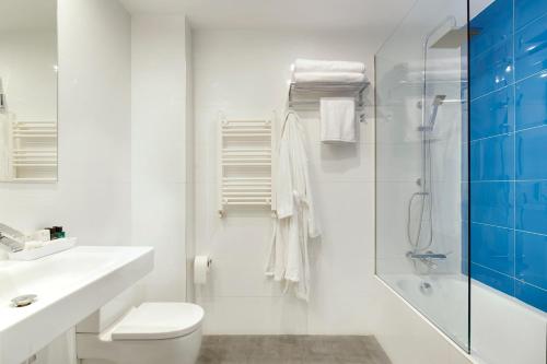 a white bathroom with a toilet and a shower at Don Cecilio Guesthouse (Centro) in San Sebastián