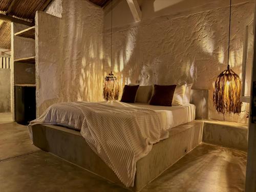 una camera da letto con un letto con due luci di Kokar Casa Hotel - Santo André a Santa Cruz Cabrália