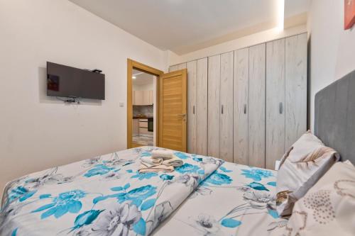 a bedroom with a bed with blue flowers on it at Vip Jovan 83 in Zlatibor