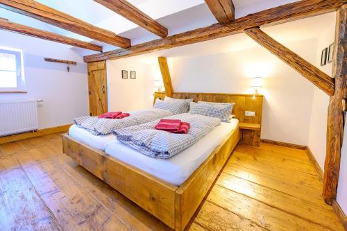 twee bedden in een kamer met houten vloeren bij Huber Xaveri - Hof in Ottenhöfen