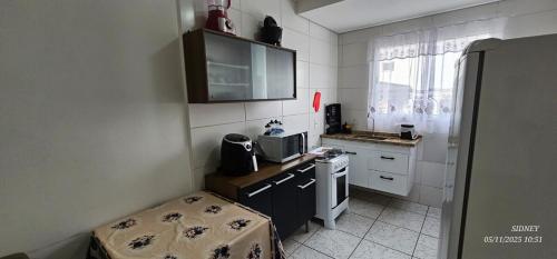 eine kleine Küche mit Spüle und Herd in der Unterkunft Apartamento 13 Balão, Paraquedas e Aventuras in Boituva