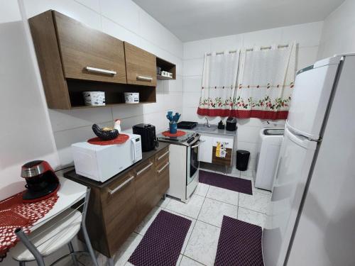una piccola cucina con frigorifero e lavandino di Apto 32. Lindo, aconchegante e completo. a Boituva