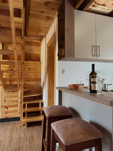 a kitchen with wooden walls and a counter with stools at Village house Gutovic in Rudinice