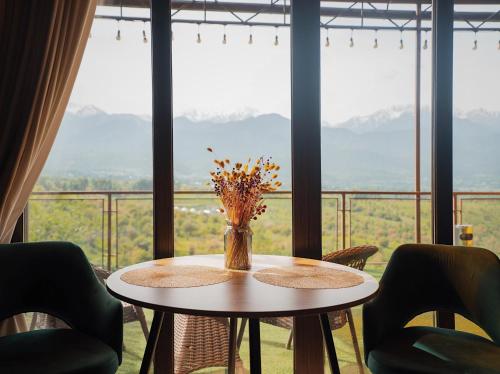 a table with a vase of flowers on a balcony at Pik Talgar Eco Village in Talghar