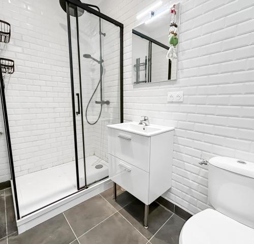 a white bathroom with a shower and a sink at La maison peinte par Eugene Delacroix - Netflix in Cambrai