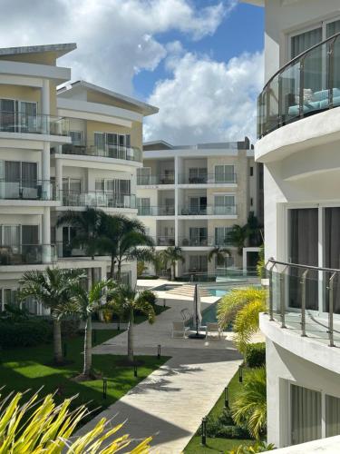蓬塔卡纳Caribbean dream beach Punta Cana的公寓大楼设有庭院和棕榈树