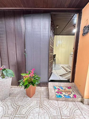 an entrance to a house with a door and a plant at Kitinete da Cris in Ilha do Mel