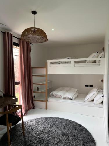 a bedroom with two bunk beds and a desk at Villa Lombardière in Gujan-Mestras