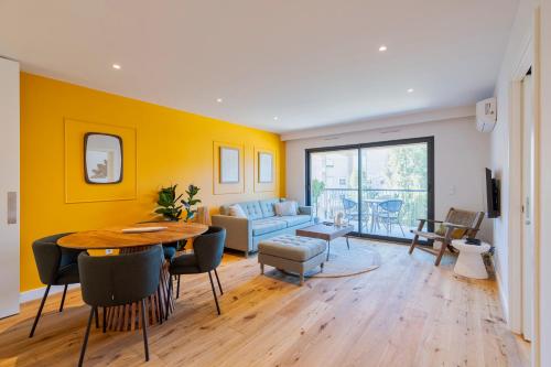 a living room with a table and a yellow wall at Quinta View Apartment, By Home Match in Setúbal