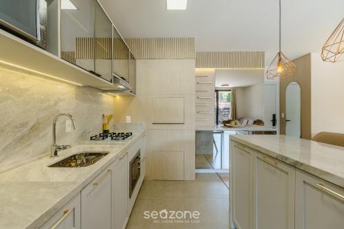a kitchen with a sink and a counter top at Acomodações modernas e completas no centro turístico de Gramado - CBGs in Gramado