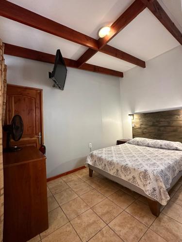 a bedroom with a bed and a tv on the wall at Hotel Plaza Colon in Arica