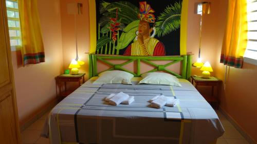 een slaapkamer met een bed met handdoeken erop bij Les Flibustiers in Sainte-Anne