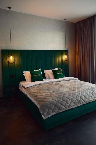a bedroom with a large bed with a green headboard at Monte Blu in Migovo