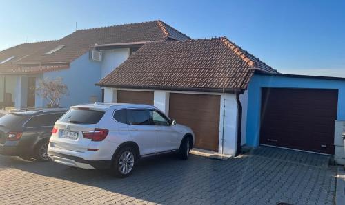 una camioneta blanca estacionada frente a una casa en Apartment with garage and garden, 