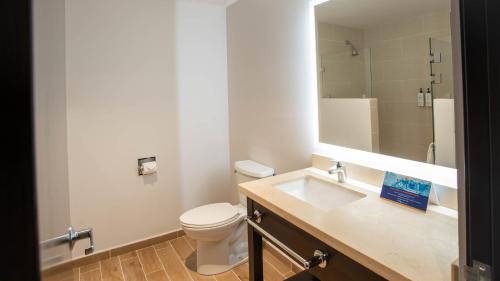 um banheiro com um vaso sanitário, uma pia e um espelho em Comfort Inn Tegucigalpa em Tegucigalpa