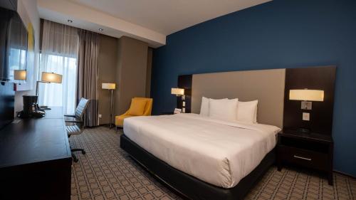 um quarto com uma cama grande e uma parede azul em Comfort Inn Tegucigalpa em Tegucigalpa