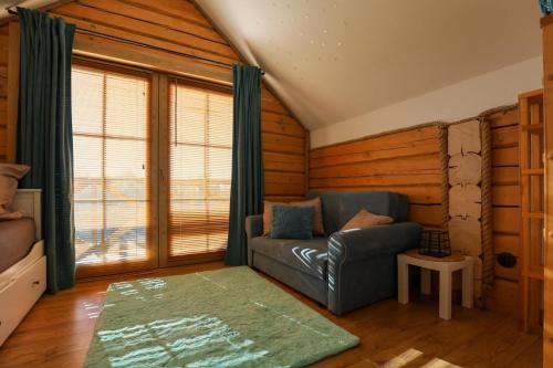 un soggiorno con divano e alcune finestre di U Henia a Potrzanowo