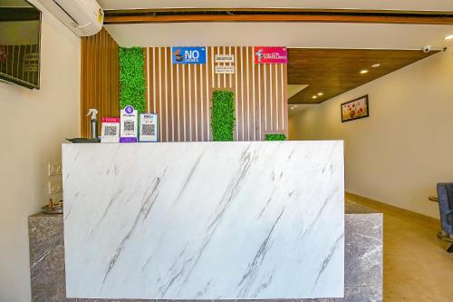 a white marble counter in a lobby with signs at Hotel Melano Ambala Chandigarh Rd Zirakpur SkyJumper park in Zirakpur