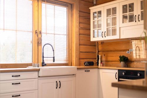 una cucina con mobili bianchi e un lavandino di U Henia a Potrzanowo