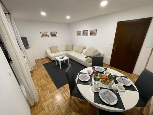 uma sala de estar com uma mesa e um sofá em Apartma Tinkara em Bled