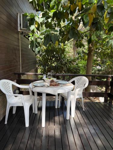 een witte tafel en stoelen op een houten terras bij Casa Azul in Mar de las Pampas