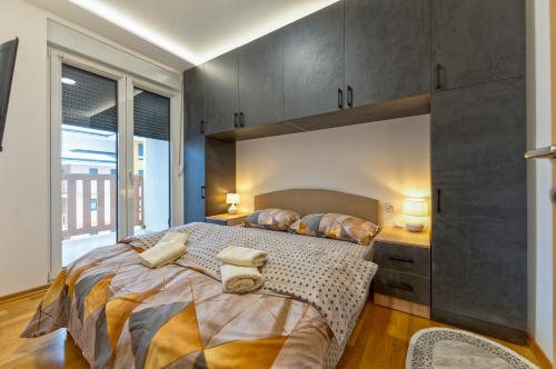 a bedroom with a large bed and a large window at Lux apartman 40 in Zlatibor