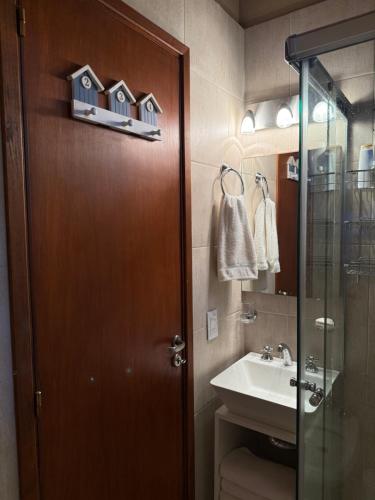 een badkamer met een wastafel en een deur met huizen erop bij Casa Azul in Mar de las Pampas