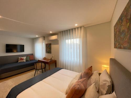 a hotel room with a bed and a couch at MyStay Porto Urban Park in Porto
