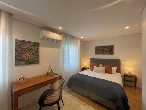 a bedroom with a bed and a desk and a bed at MyStay Porto Urban Park in Porto