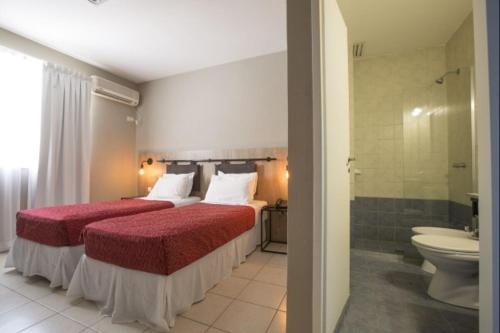 a hotel room with a bed and a bathroom at Vilaró Art Wine Hotel in Buenos Aires