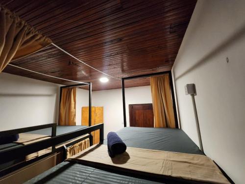 a bedroom with two beds and a wooden ceiling at Ryo hostel in Ahangama