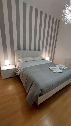 una camera con un grande letto con testiera a righe di Casa Mamus 2 a Pescara