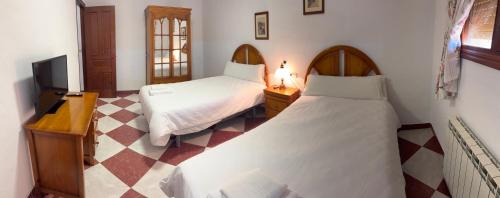 een slaapkamer met twee bedden en een televisie bij Alojamiento Rural Dilamor in El Picazo