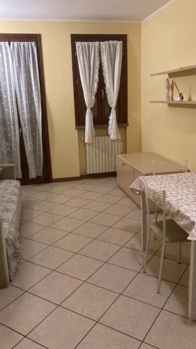 a living room with a tiled floor and two windows at Apartament Orio 3 in Orio al Serio