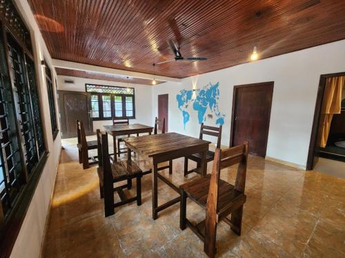 a dining room with a wooden table and chairs at Ryo hostel in Ahangama