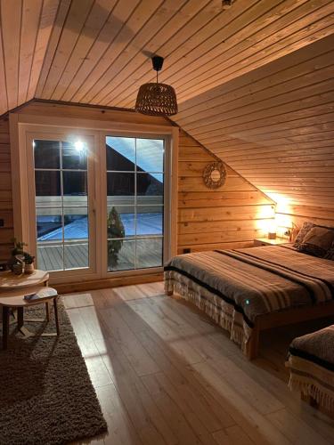 KupiškisSodyba vienkiemyje "Šeimos slėnis"的一间卧室，里面有一张床和一扇大窗户。