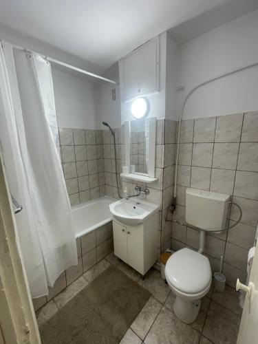 a bathroom with a toilet and a sink and a tub at Studio Modest in Craiova