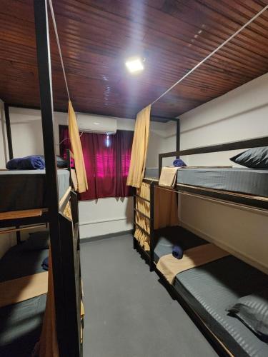 a room with three bunk beds and a window at Ryo hostel in Ahangama