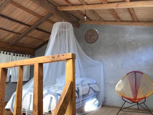 a bedroom with a bed with a mosquito net at Cabaña de descanso en Tlazala in Cedro