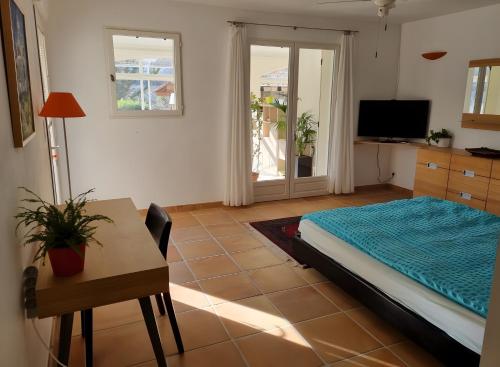 ein Zimmer mit einem Bett und einem Tisch und einem Schreibtisch in der Unterkunft Chambre D'hôtes - Les Hirondelles in Mirabel-aux-Baronnies