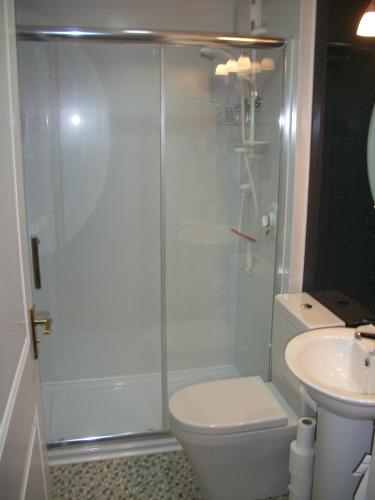 a bathroom with a shower and a toilet and a sink at Premier Room in Kelso