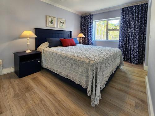una camera da letto con un letto grande e una finestra di Living Lagoon Two Apartments a Brenton-on-Sea