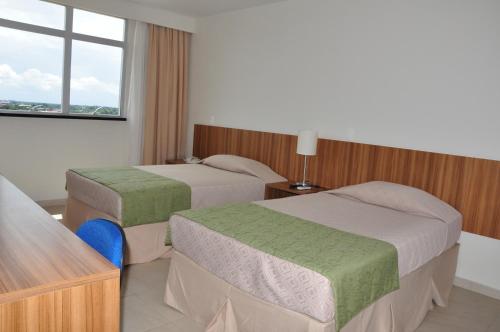 um quarto de hotel com duas camas e uma janela em Boa Vista Eco Hotel em Boa Vista