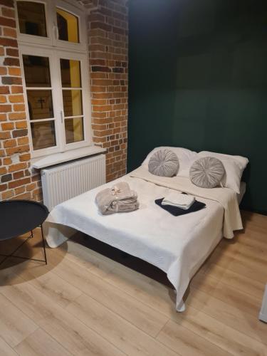 Bett in einem Zimmer mit Ziegelwand in der Unterkunft Piernikowy Strumyk in Toruń