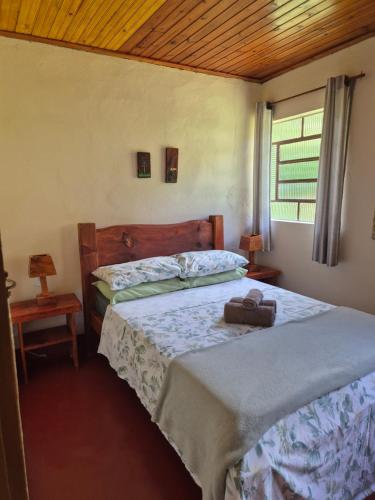 a bedroom with two beds and a window at Chalé 01 maritacas in Cunha