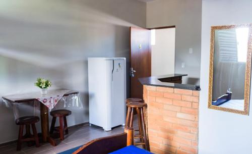 una cucina con frigorifero e tavolo con sgabelli di Chales sol e mar a Ubatuba