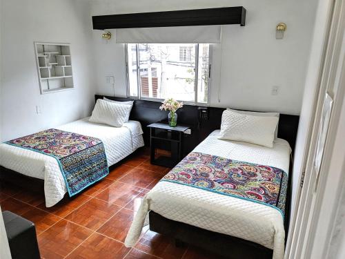 a room with two beds and a window at Hotel Villa Karina in Bogotá