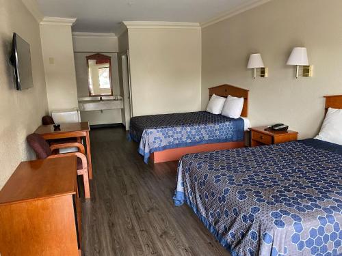 a hotel room with two beds and a desk at Crystal Inn - NASA Webster in Webster