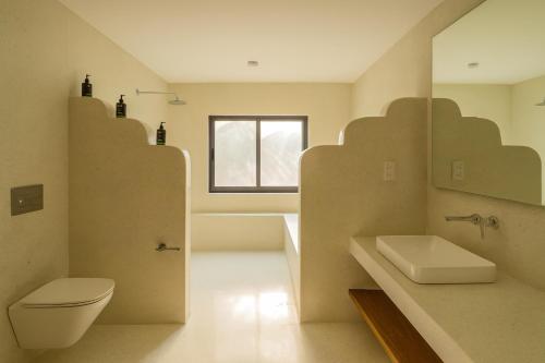 un bagno con lavandino, WC e finestra di Casa Del Mar Villa by YourHost 5B – Nyali Mombasa a Mombasa